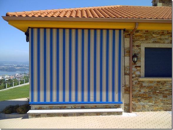 Toldo cortina en tejido acrílico, color venus y estructura lacada en azul combinando con los toldos delanteros